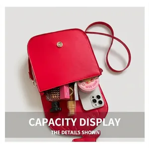 Vue de dessus du sac bandoulière rouge montrant sa capacité pour téléphone et maquillage