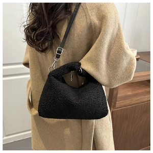 Dettaglio borsa a tracolla in pile nero indossata su cappotto color cammello