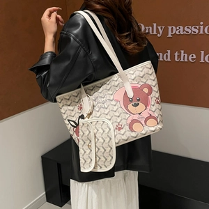 Chic beige tote bag with grey pattern and cartoon bear, shown on model as a shoulder bag