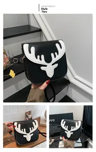 Detail view of monochrome crossbody bag featuring white reindeer motif and gold hardware