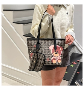 Detail of Goyard-style geometric tote bag featuring a cute cartoon bear and small pouch