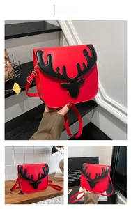 Detail of red Christmas crossbody bag with black deer antler design and gold hardware