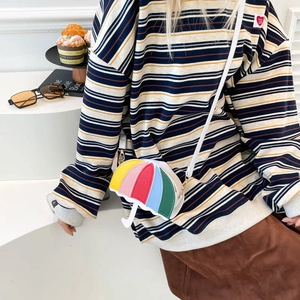 Colorful umbrella-shaped crossbody bag with vibrant patchwork design on a model