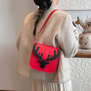 Sac bandoulière renne rouge au design élan 3D porté sur un manteau en tweed beige