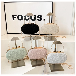 Detail of hard-shell evening clutch bags with metallic handles and bow clasps in five colors