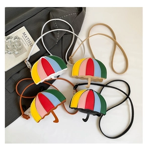 Miniature umbrella-shaped crossbody bags in assorted colors on a clean white surface