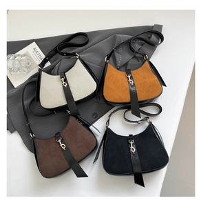 Detail showing crescent bags in beige, orange, and black with unique golden metal hooks