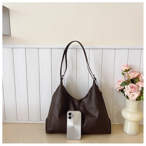 Détail du grand sac cabas en cuir marron foncé avec smartphone pour référence de taille