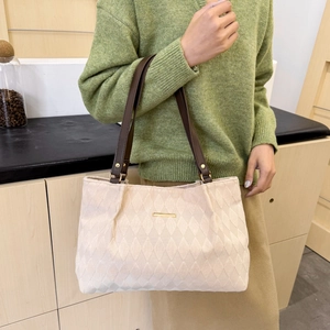 Chic beige quilted tote bag with brown straps shown in a lifestyle setting