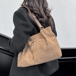 Brown quilted tote bag with matte finish and gold hardware shown from a side view