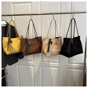 Détail de quatre sacs fourre-tout en daim de différentes couleurs avec nœuds rayés