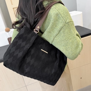 Black quilted tote bag with brown leather straps and spacious interior for women