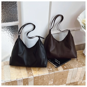 Detailed close-up of large minimalist tote bags in black and brown with adjustable straps