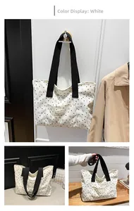 Close-up of white canvas tote with heart patterns and FASHION leather tag detail