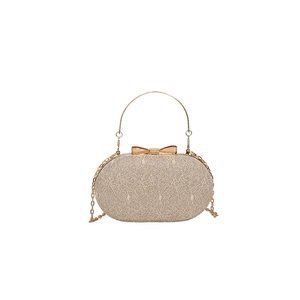 Champagne gold evening bag with a metallic bow clasp and circular handle on white background