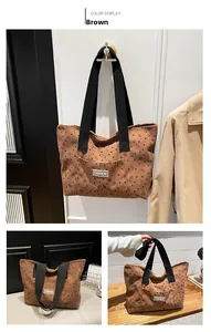 Detail view of brown corduroy tote bag with heart patterns and fashion label