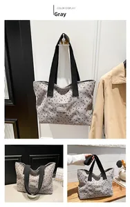 Detailed view of grey corduroy tote bag with black heart and bow prints and top handles