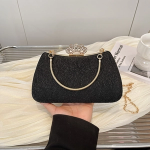 Detail of black lace evening clutch bag with pearl crown buckle and gold chain strap