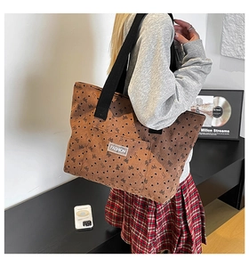 Brown corduroy tote bag detail with black heart bow prints and front fashion label