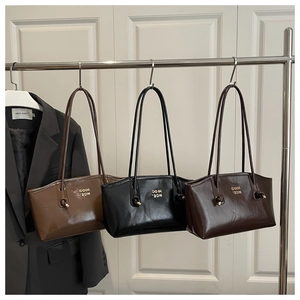 Minimalist vintage tote bags in black, brown and dark coffee hung on a metal rack
