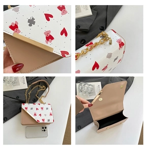 Détail du sac bandoulière imprimé ours cerise avec ferrures dorées et bandoulière chaîne