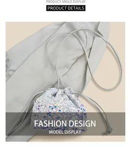 Dettaglio borsa a secchiello con paillettes olografiche e coulisse su tessuto bianco