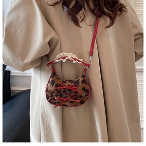 Dettaglio mini borsa leopardata con fiocchi rossi, manico in pizzo e tracolla