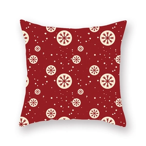 Détail de la housse de coussin de Noël avec flocons de neige sur tissu rouge vif