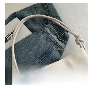 Dettaglio borsa a scacchi crema con bordo in pizzo bianco e logo metallico JINGPIN