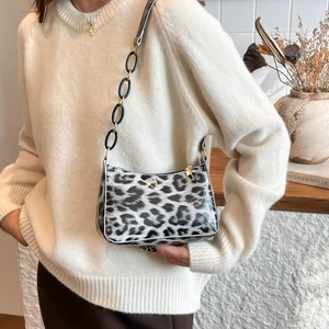 Fashionable leopard print shoulder bag with gold chain strap shown on model's shoulder