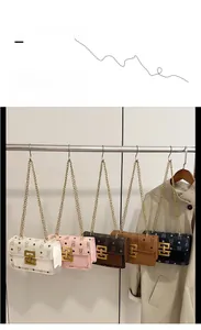 Détail de cinq sacs bandoulière avec chaînes en métal doré et motifs monogrammes