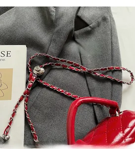 Macro detail of red quilted leather handbag with silver metal and leather chain strap