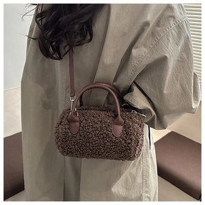 Borsa bowling marrone in ecopelliccia su trench beige con manici in pelle scura