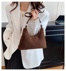 Détail de la texture en peluche marron et de la bandoulière en cuir du sac selle chic