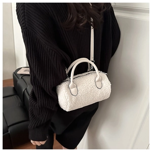 Mini borsa a cilindro in ecopelliccia bianca indossata da una modella in maglione nero