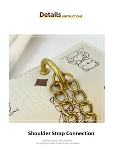 Détail de la bandoulière en cuir crème avec chaîne dorée et motif ours de ce sac