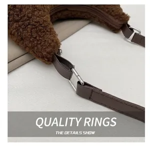 Detailed macro view of the brown plush shoulder bag showing metal ring and leather strap sewing