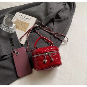 Détail du mini sac matelassé rouge avec chaîne argentée et breloque de cœur
