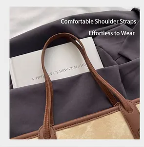 Detail of brown leather strap on beige canvas tote bag with clean stitching finish