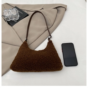 Détail du sac à bandoulière en peluche marron doux avec une sangle foncée lisse