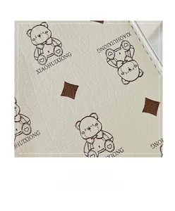 Vue détaillée du cuir grainé crème avec un imprimé d'ours de dessin animé mignon