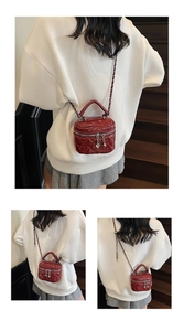 Detail view of mini burgundy quilted box bag with heart charm and chain strap on model