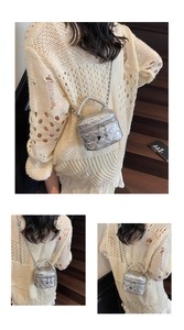 Detail of silver quilted mini box bag with metallic chain strap and handle design