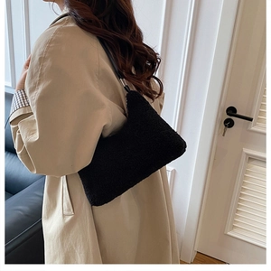 Détail du sac sous le bras en fausse fourrure noire avec bandoulière cuir pour mode d'hiver