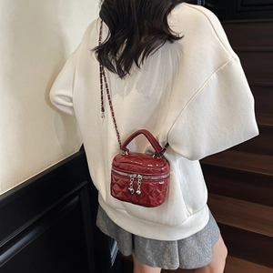 Détail du mini sac boîte matelassé bordeaux avec bandoulière chaîne et breloque cœur