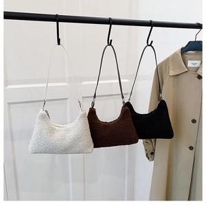 Tre borse tote in pile peluche nei colori crema marrone e nero appese a una porta