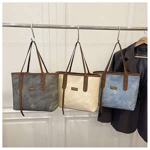 Detailed row of marble-patterned tote bags in grey, beige, and blue with leather handles