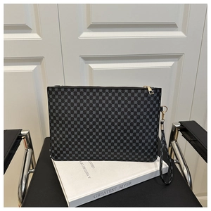 Détail d'une pochette noire avec motifs géométriques gris et fermeture éclair dorée