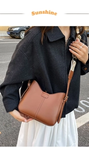 Détail du sac en cuir marron caramel avec une large bandoulière en jacquard à motifs