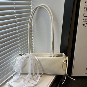 Chic beige baguette shoulder bag with elegant lace bow detail and glossy leather finish
